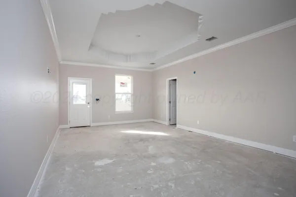 a view of an empty room with window and a kitchen