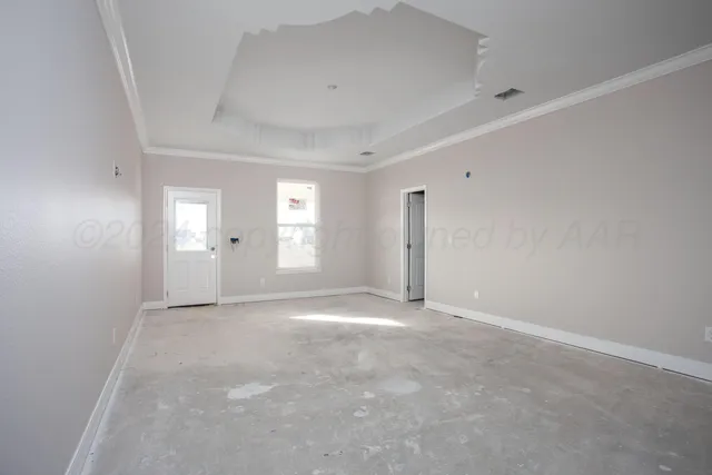 a view of an empty room with window and a kitchen