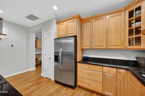 a kitchen with granite countertop a refrigerator and cabinets