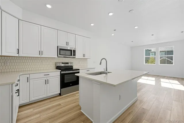 a kitchen with sink a microwave and cabinets
