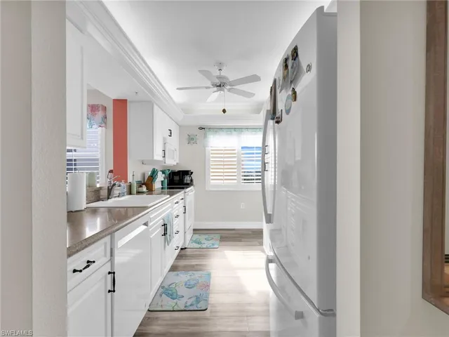 a large white kitchen with granite countertop a sink