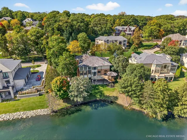 an aerial view of residential houses with outdoor space and lake view
