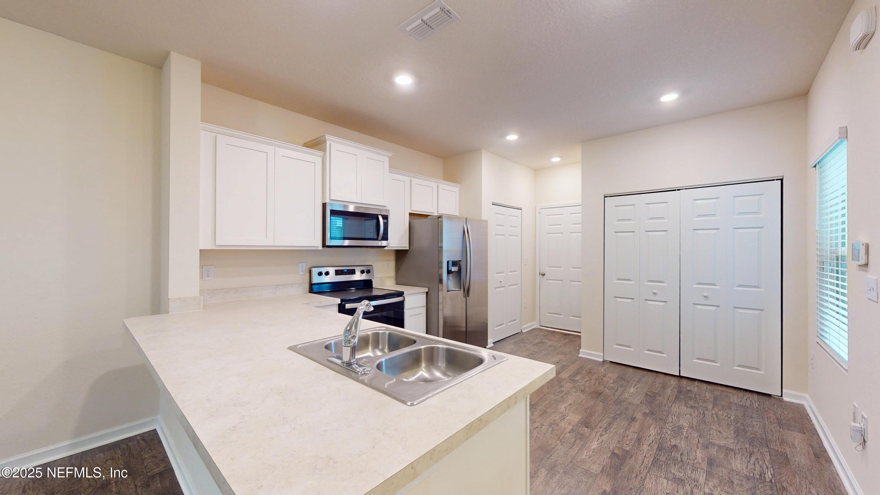 93 Scotch Pebble Drive Jacksonville, FL 32259 - Photo 4 of 27 a kitchen with stainless steel appliances granite countertop a sink refrigerator and microwave