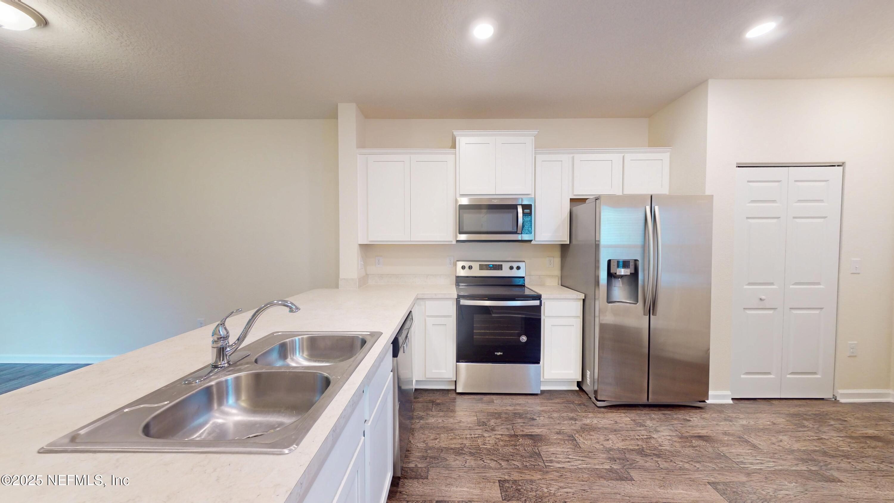 93 Scotch Pebble Drive Jacksonville, FL 32259 - Photo 5 of 27 a kitchen with a sink a refrigerator and cabinets