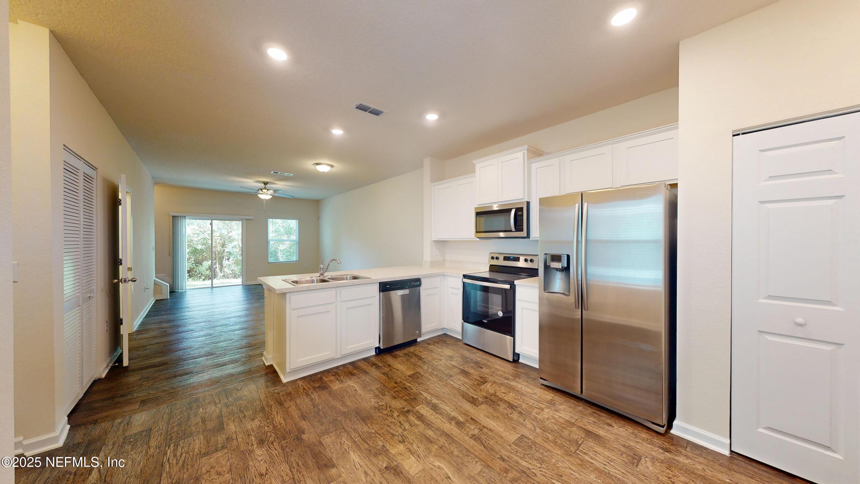 93 Scotch Pebble Drive Jacksonville, FL 32259 - Photo 6 of 27 a kitchen with a refrigerator and a stove top oven