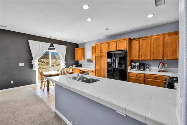 a kitchen with stainless steel appliances granite countertop sink refrigerator and window