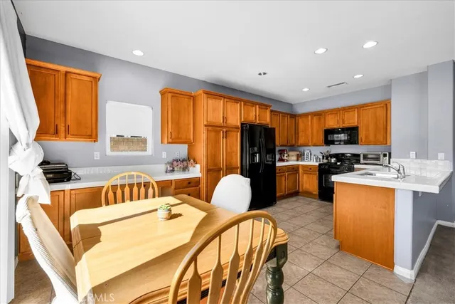 a kitchen with stainless steel appliances granite countertop sink stove refrigerator and cabinets