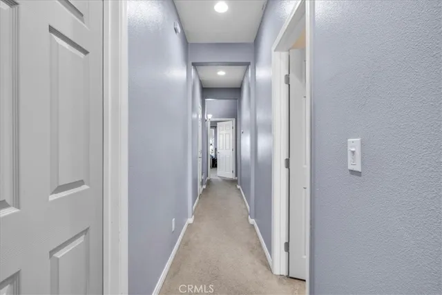 a view of a hallway with wooden shelves