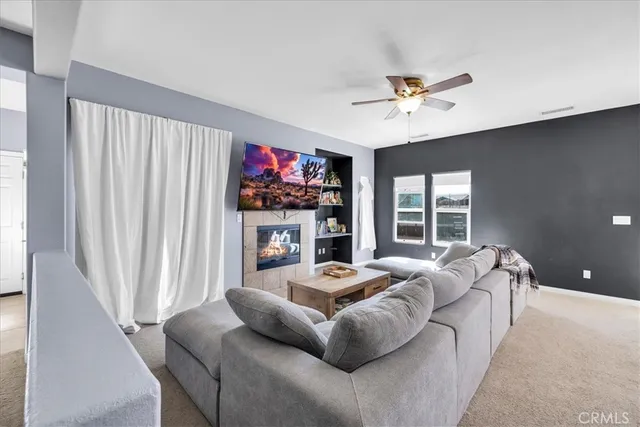 a living room with furniture a flat screen tv and a fireplace