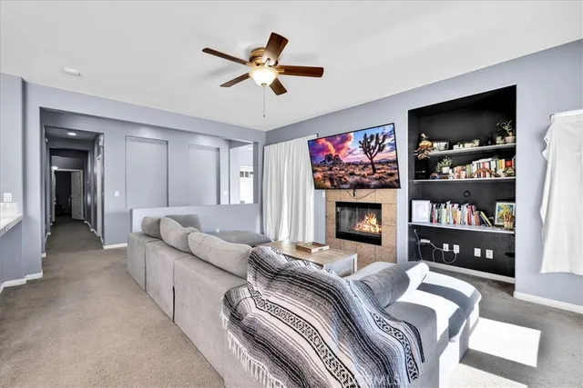 a living room with furniture a flat screen tv and a fireplace