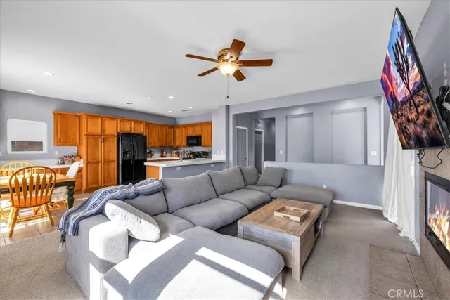 a living room with furniture a ceiling fan and a window