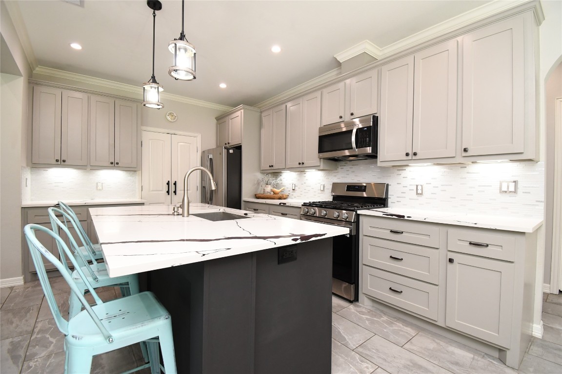 2406 Hummingbird Street New Caney, TX 77357 - Photo 11 of 40 a kitchen with cabinets appliances and a center island
