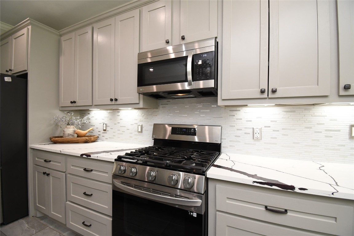 2406 Hummingbird Street New Caney, TX 77357 - Photo 12 of 40 a kitchen with granite countertop white cabinets and stainless steel appliances