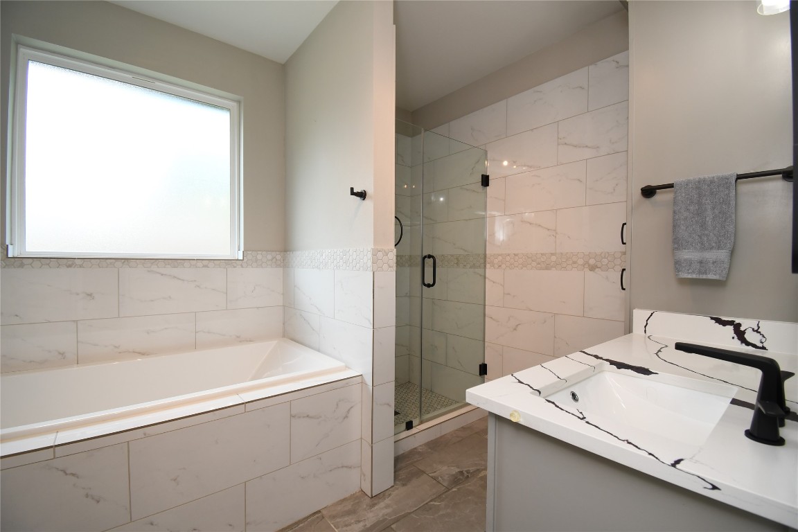 2406 Hummingbird Street New Caney, TX 77357 - Photo 22 of 40 a bathroom with a tub sink and mirror