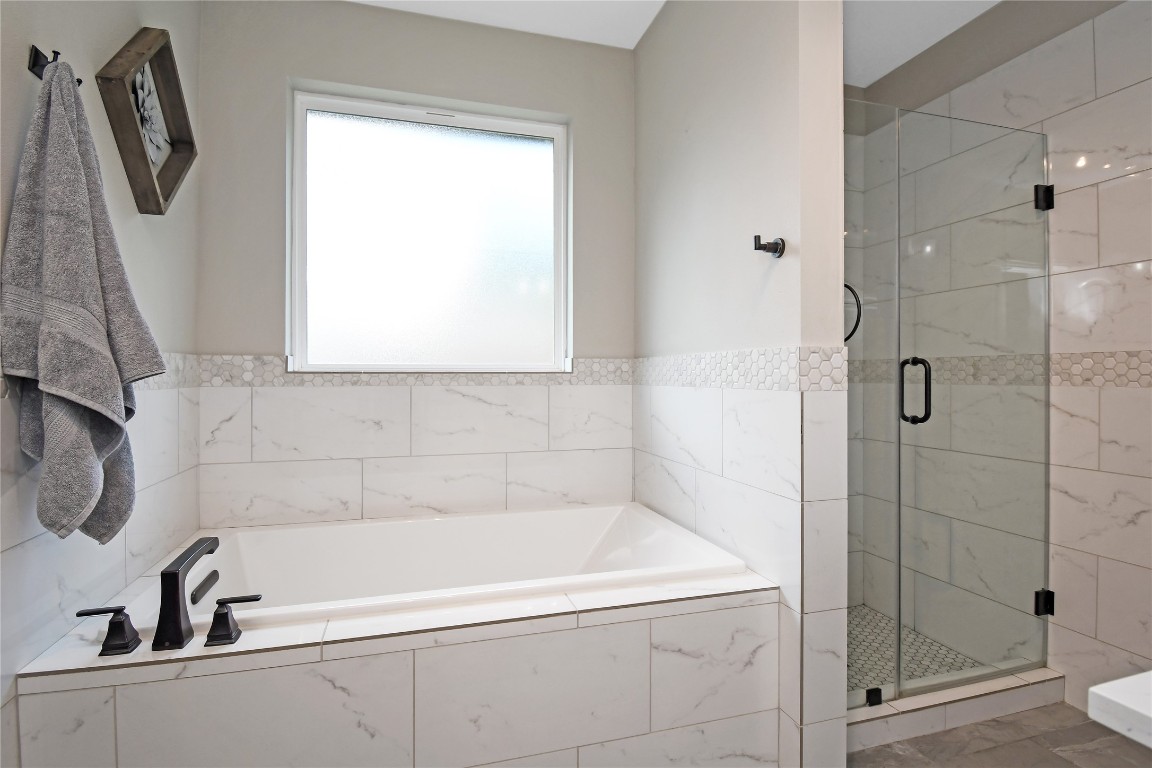 2406 Hummingbird Street New Caney, TX 77357 - Photo 25 of 40 a bathroom with a bathtub and a shower