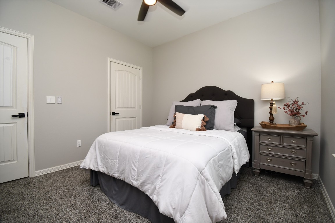 2406 Hummingbird Street New Caney, TX 77357 - Photo 26 of 40 a bedroom with a bed and a chandelier