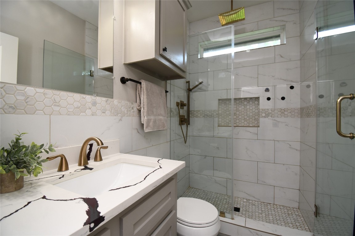 2406 Hummingbird Street New Caney, TX 77357 - Photo 27 of 40 a bathroom with a sink toilet and shower