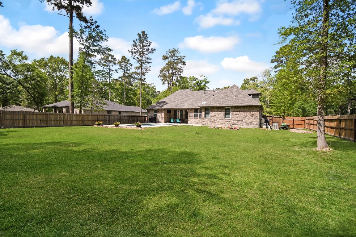 2406 Hummingbird Street New Caney, TX 77357 - Photo 38 of 40 a front view of a house with garden