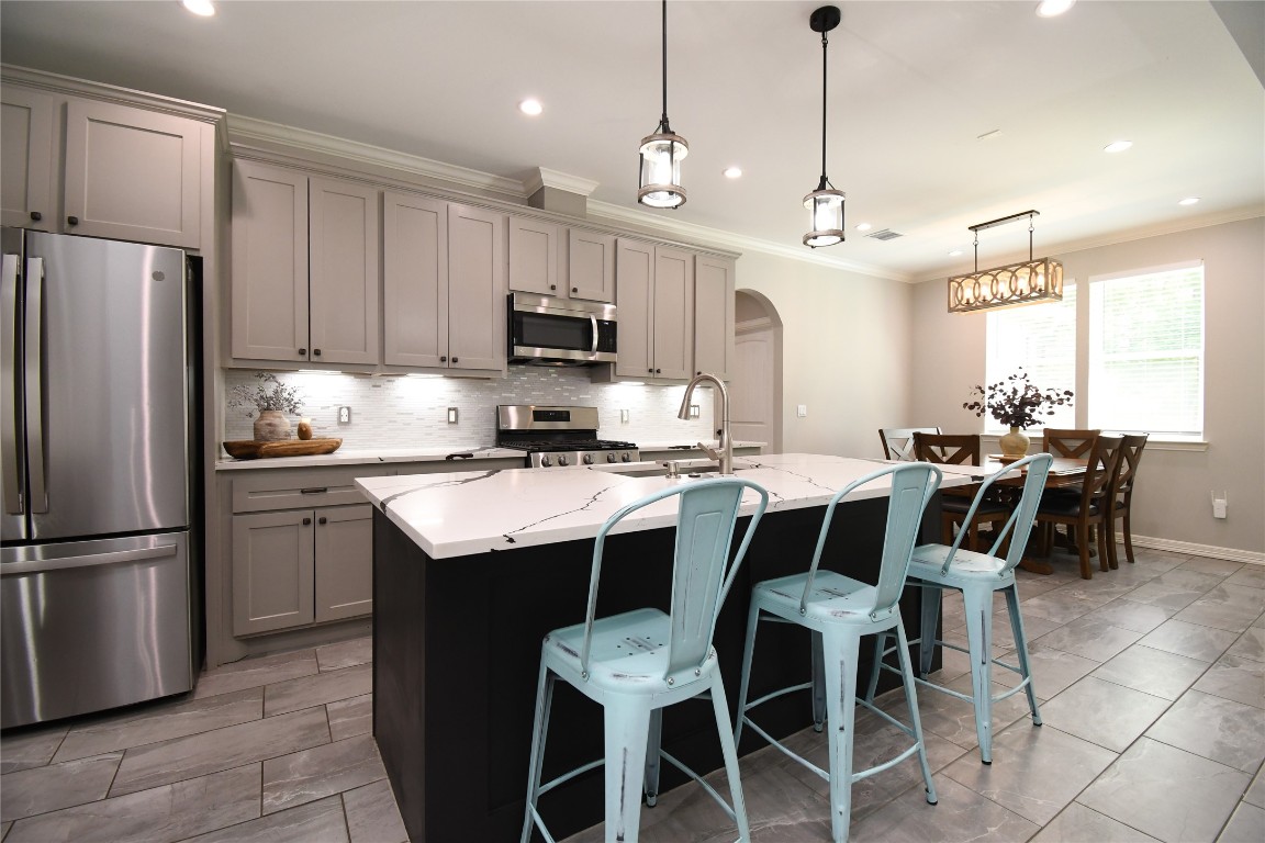 2406 Hummingbird Street New Caney, TX 77357 - Photo 8 of 40 a kitchen with kitchen island granite countertop a center island and stainless steel appliances