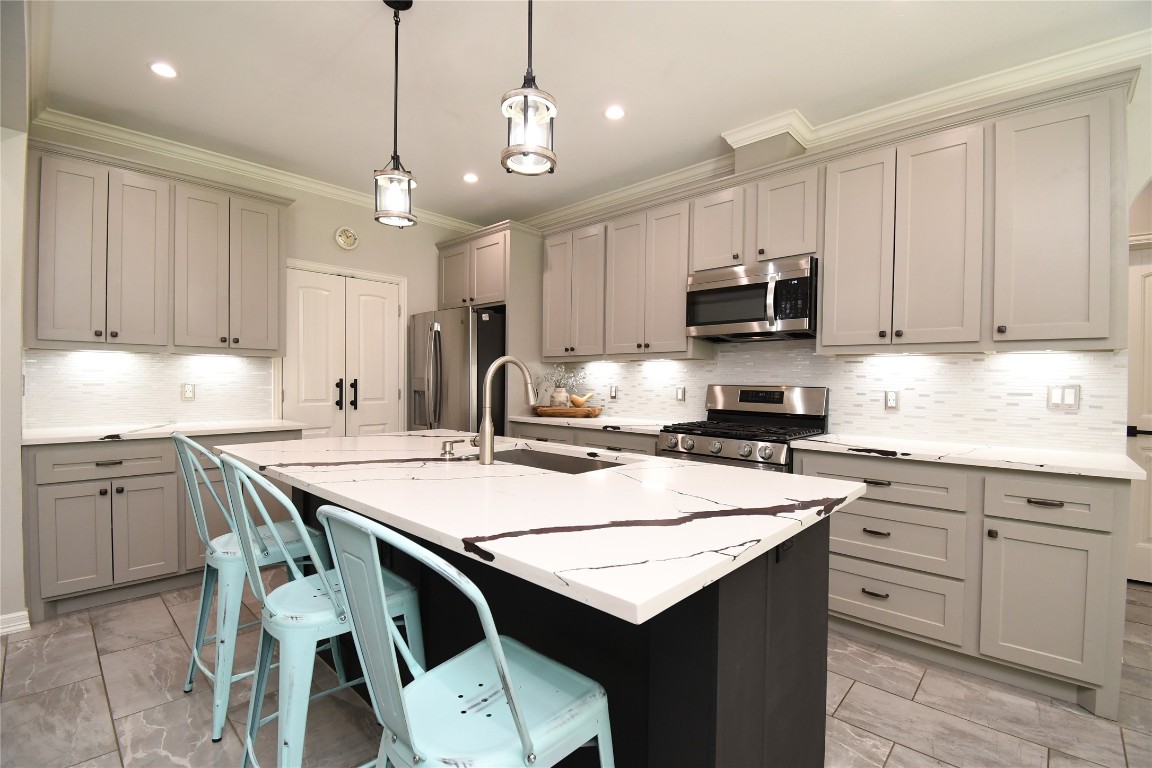 2406 Hummingbird Street New Caney, TX 77357 - Photo 10 of 40 a kitchen with kitchen island granite countertop a table chairs sink and cabinets