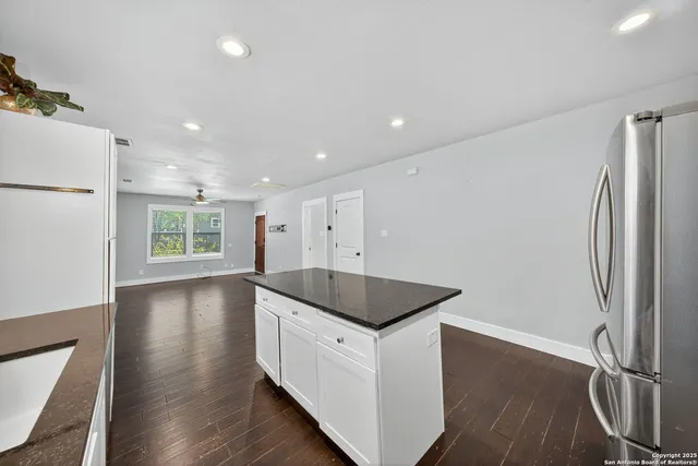 a kitchen with stainless steel appliances granite countertop a refrigerator a sink and a stove