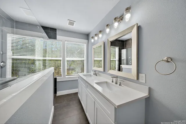 a bathroom with a sink double vanity and a large mirror