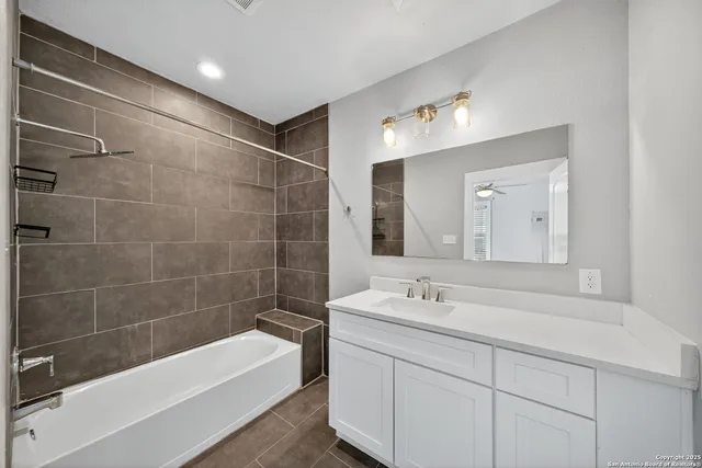 a bathroom with a tub a sink and mirror