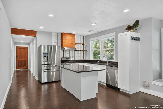 a kitchen with stainless steel appliances granite countertop a refrigerator and a sink