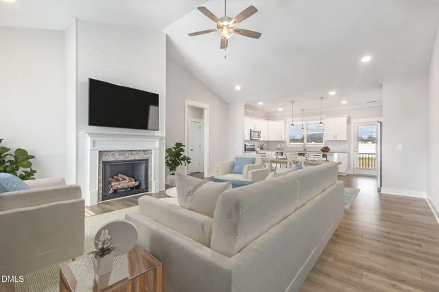 an empty room with wooden floor ceiling fan and windows