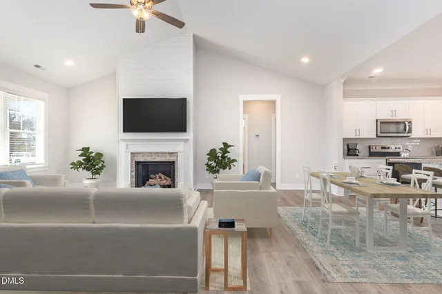 an empty room with wooden floor ceiling fan and windows