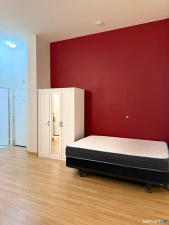 a bedroom with a bed and a potted plant