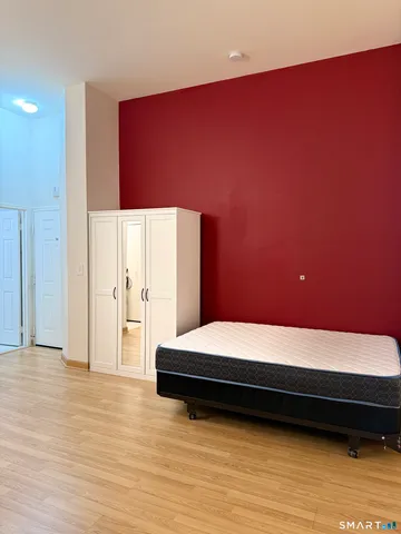 a bedroom with a bed and a potted plant