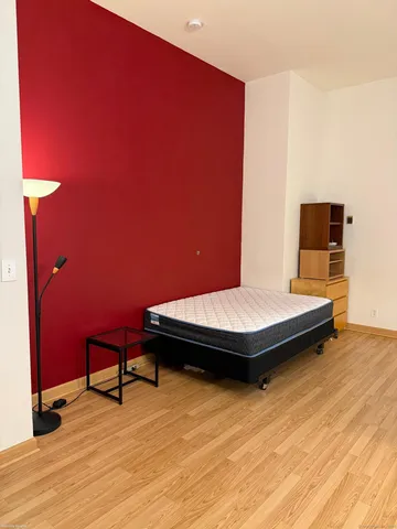 a bedroom with a bed and wooden floor