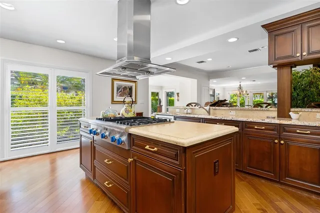 a kitchen with a stove a sink a refrigerator and wooden floor