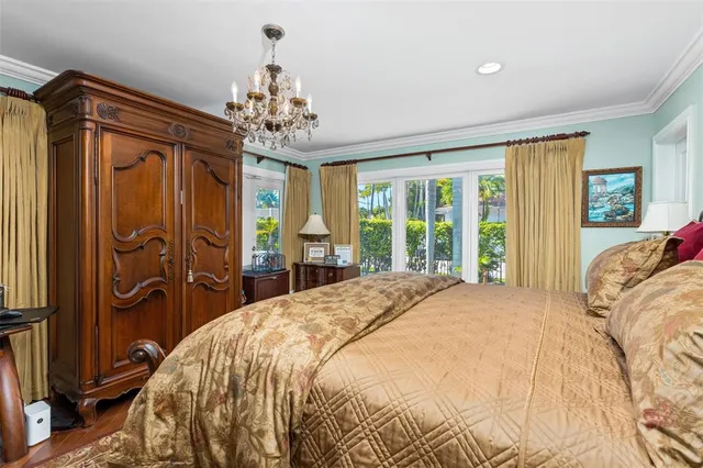 a spacious bedroom with a large bed and a chandelier