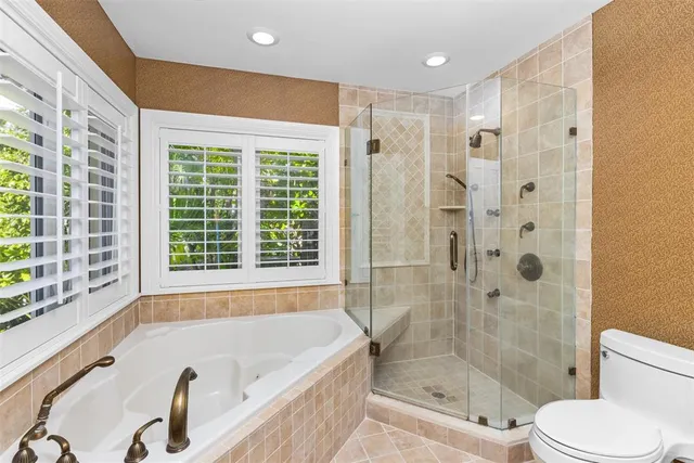 a bathroom with a granite countertop tub toilet and a sink