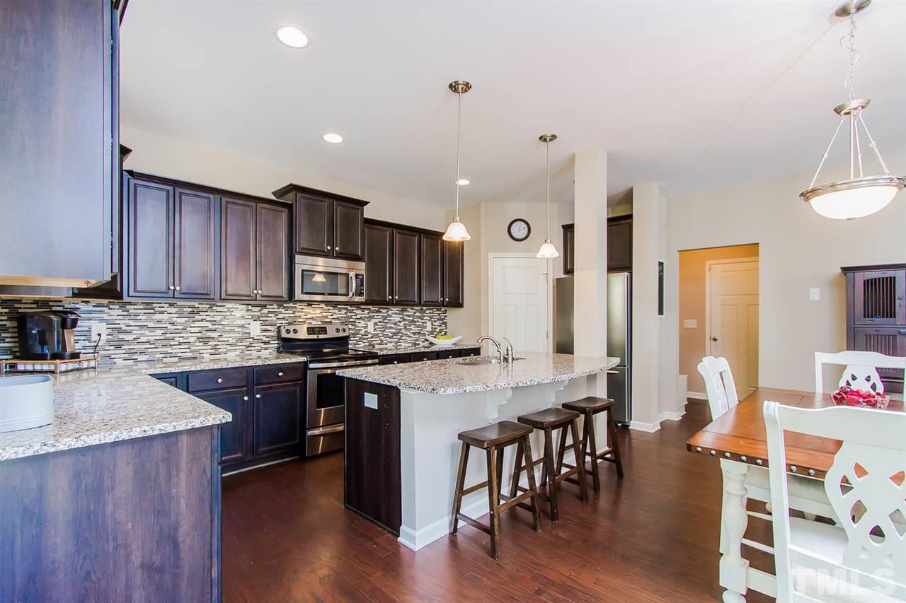 1401 Ranchester Road Knightdale, NC 27545 - Photo 11 of 24 Gourmet Kitchen boasts stunning backsplash, granite, stainless steel appliances, island w/ sink, and hardwood floors.