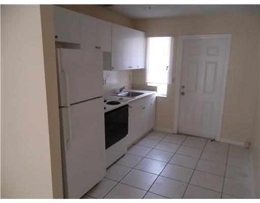 1176 West 32nd Street Riviera Beach, FL 33404 - Photo 3 of 10 a kitchen with a stove a refrigerator and cabinets
