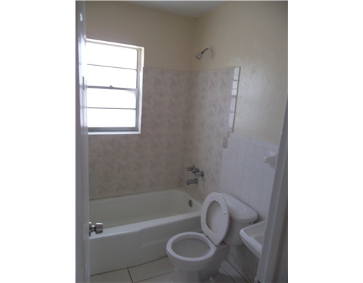 1176 West 32nd Street Riviera Beach, FL 33404 - Photo 8 of 10 a bathroom with a sink and a bathtub