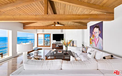 a view of a dining room with furniture wooden floor and a floor to ceiling window