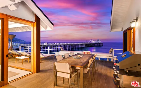 a view of a patio with dining table and chairs