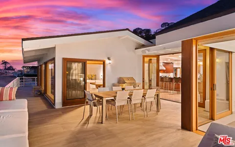 a roof deck with a table and chairs