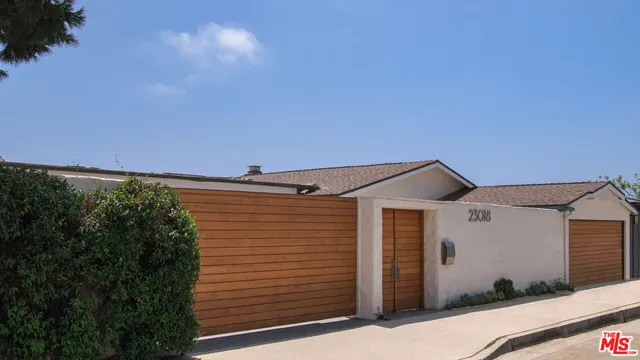 an aerial view of residential houses with outdoor space and trees