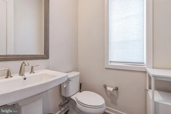 a bathroom with a toilet a sink a vanity and mirror