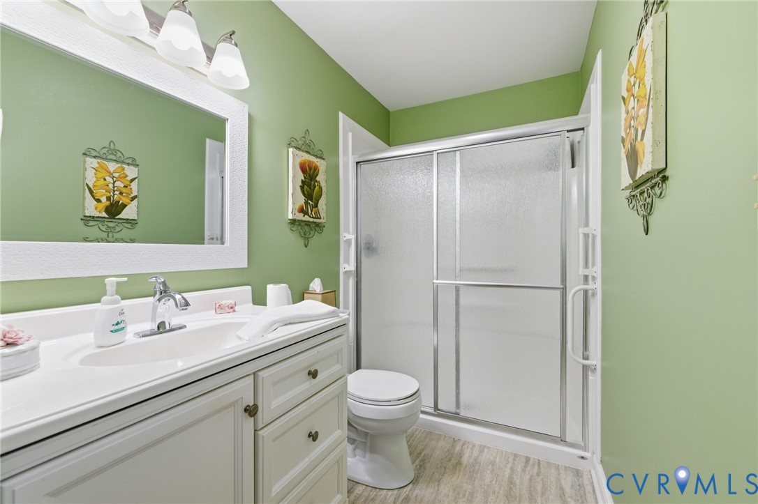 6606 West Quaker Road Disputanta, VA 23842 - Photo 26 of 32 Full bathroom with vanity, a stall shower, and LVP