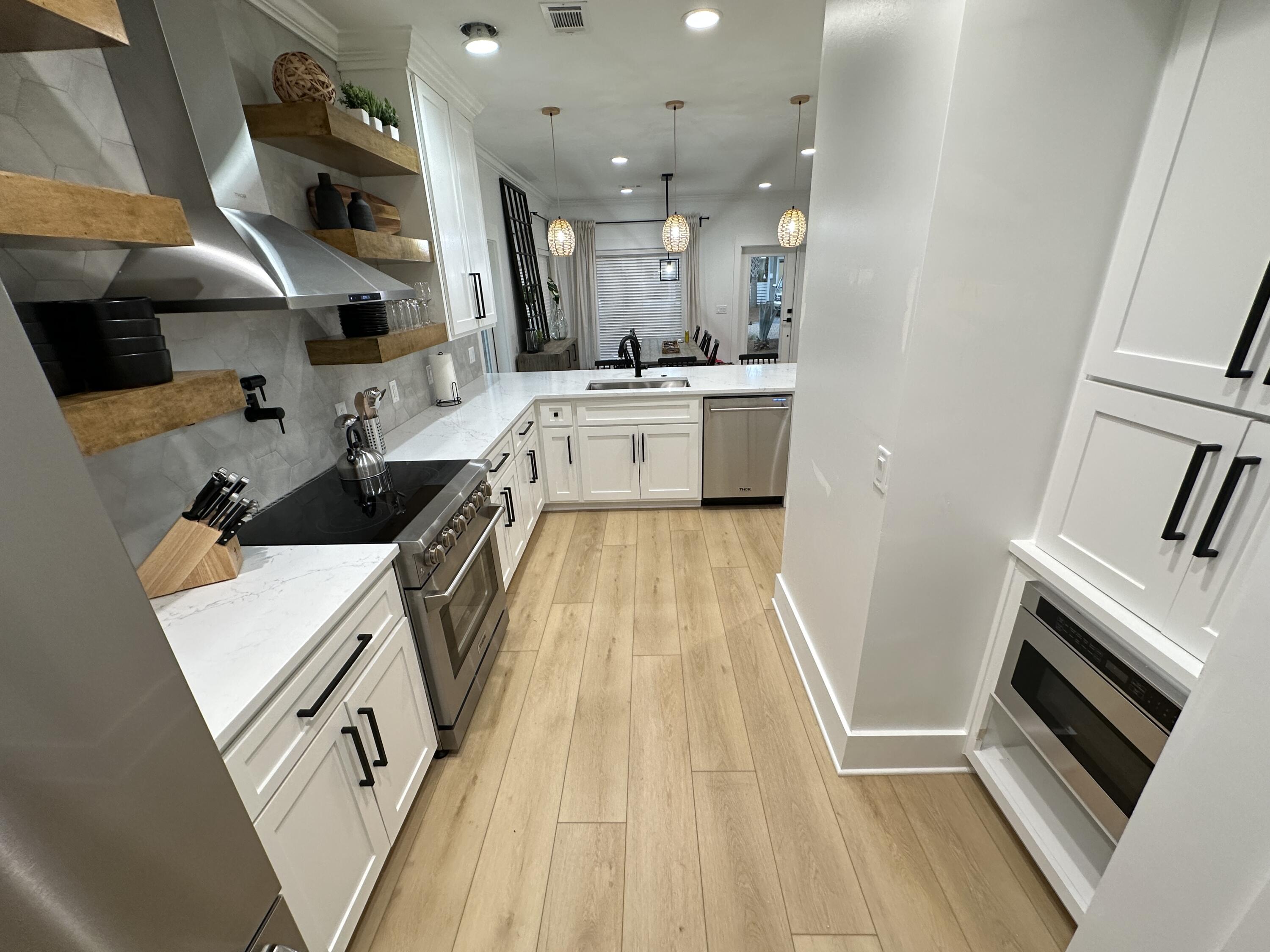 48 Rue Du Soleil Santa Rosa Beach, FL 32459 - Photo 20 of 37 a kitchen with white cabinets and sink