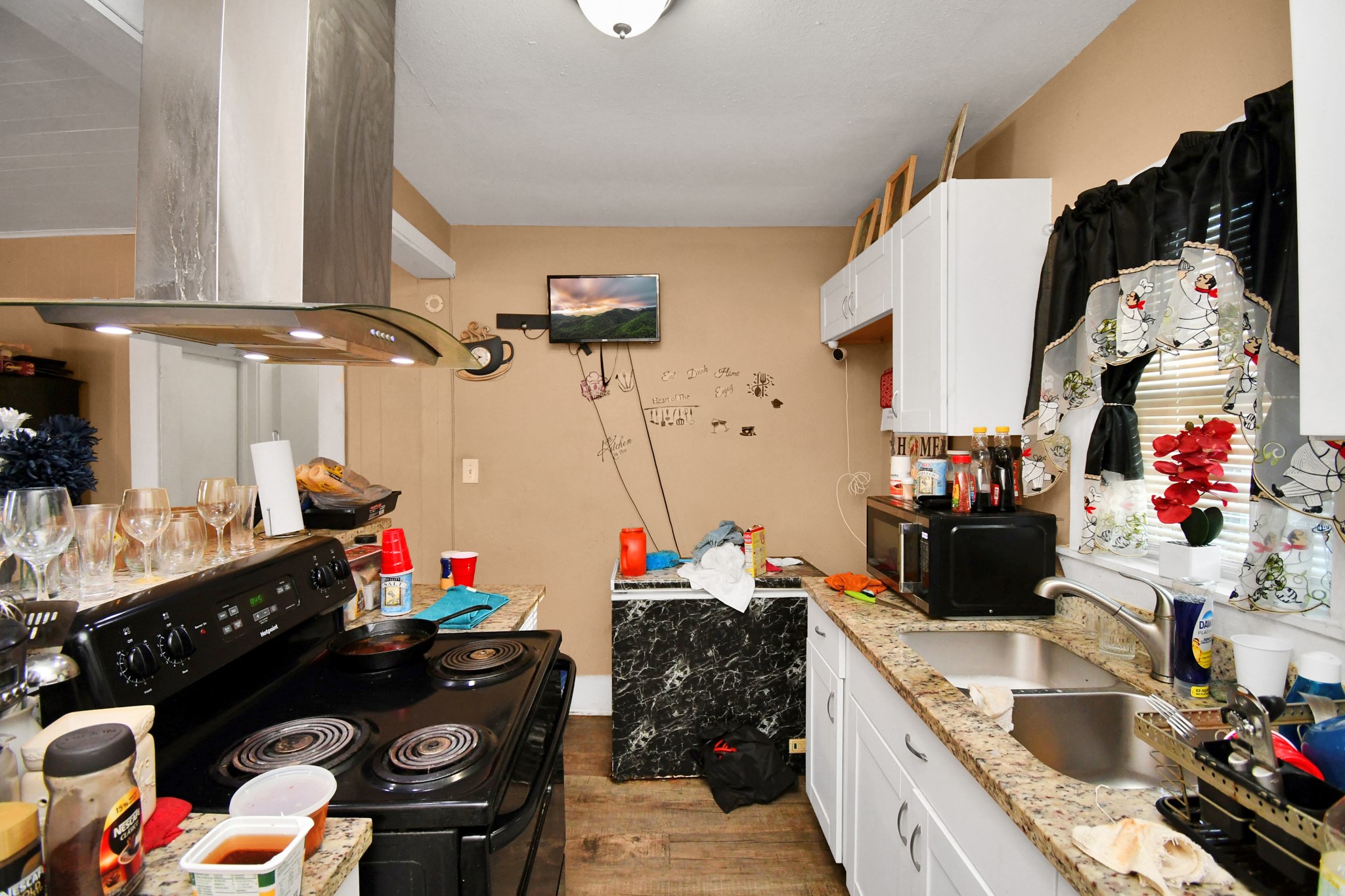 3818 Drew Street Houston, TX 77004 - Photo 19 of 35 a kitchen with lots of clutter and appliances