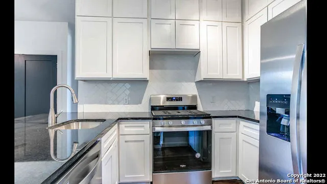 a kitchen with kitchen island granite countertop a sink stainless steel appliances and cabinets