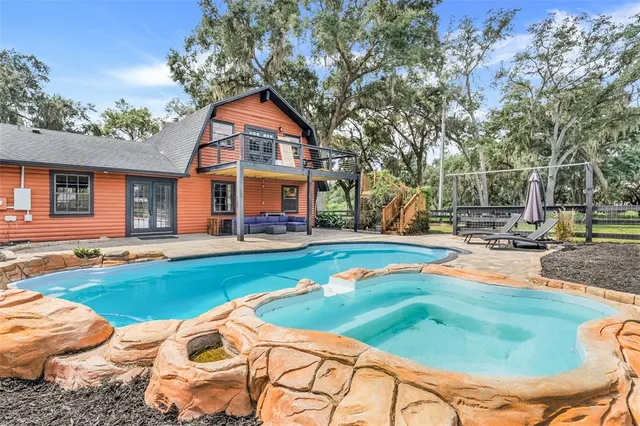 a swimming pool with outdoor seating and yard