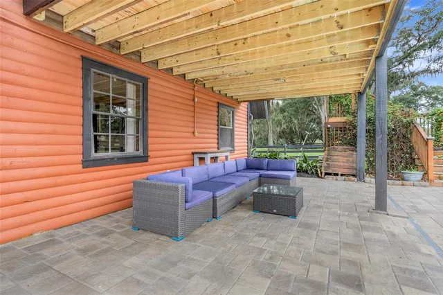 a view of a patio with a table and chairs under an umbrella
